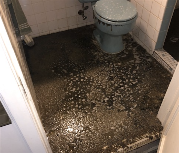 a bathroom with black sludge on the floor